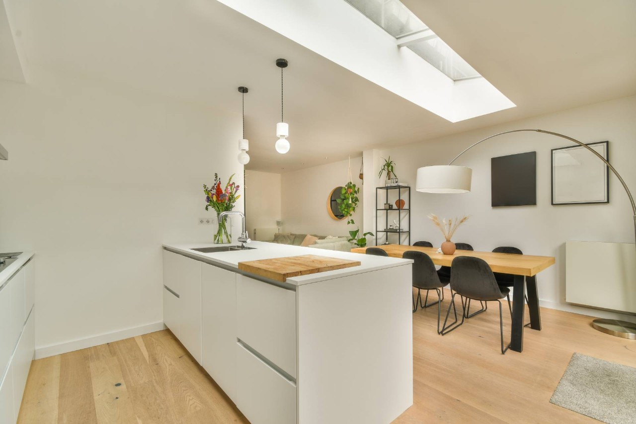 A white, sleek, and modern kitchen with skylights, filtering natural light into the space at Blind King near Providence, RI