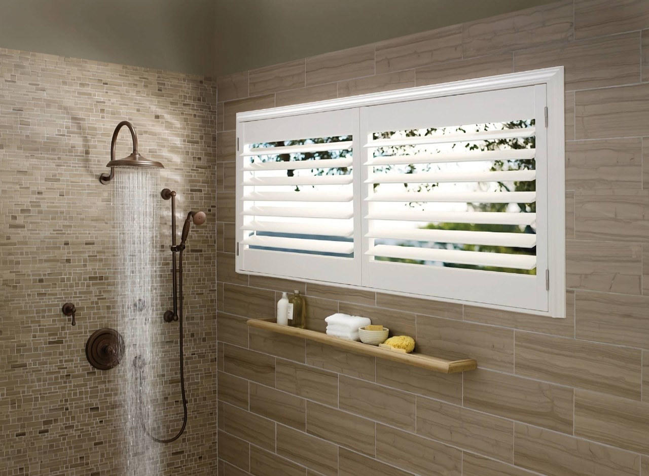Hunter Douglas Palm Beach™ Polysatin™ Vinyl Shutters on a small, wide window inside a modern showerat Blind King near Providence, RI